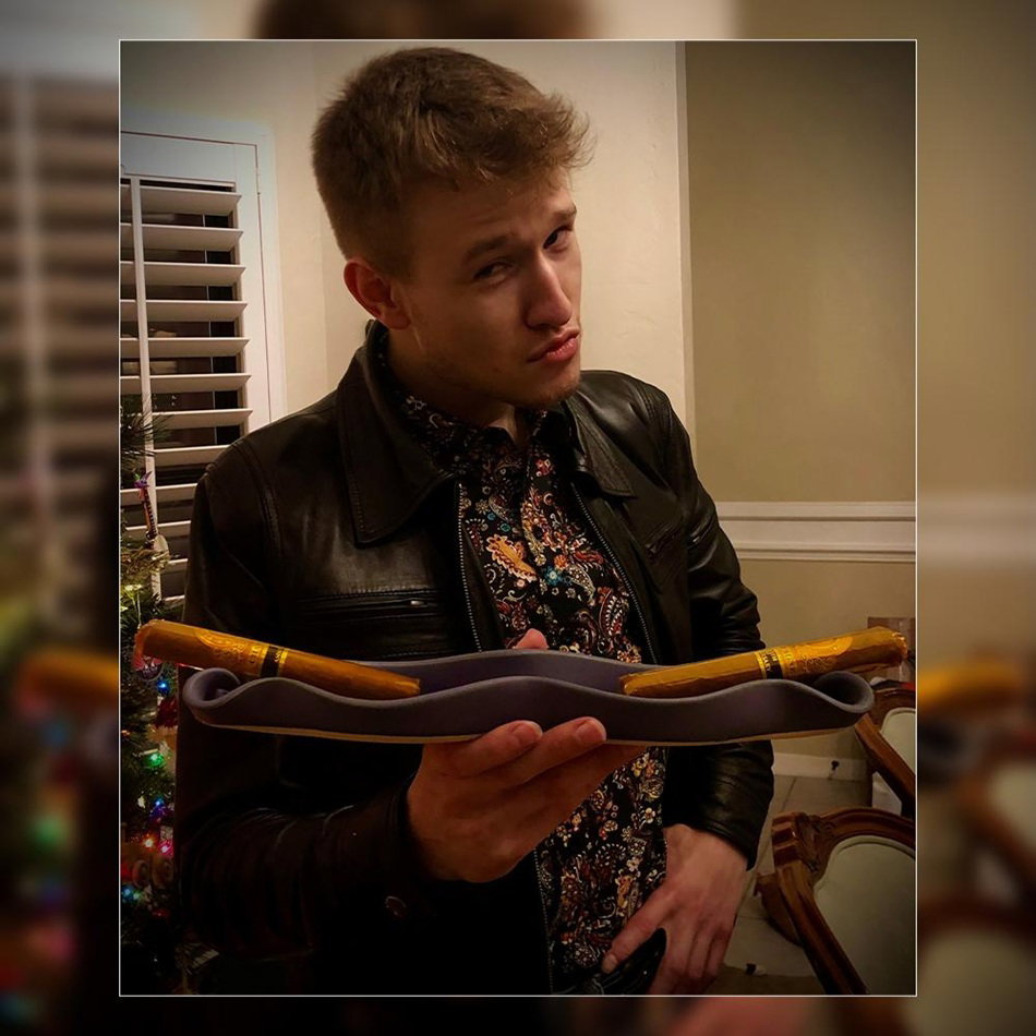 Cory Carnley Holding Two Cigars Indoors