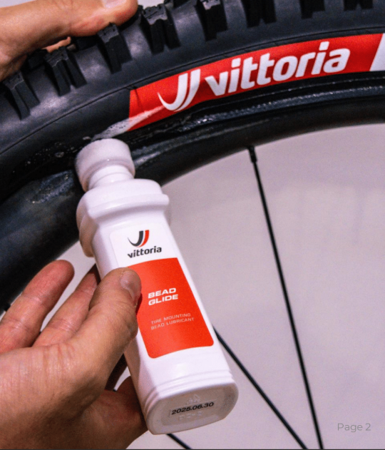 Mano che applica Vittoria Bead Glide sul tallone del pneumatico montato sul cerchio