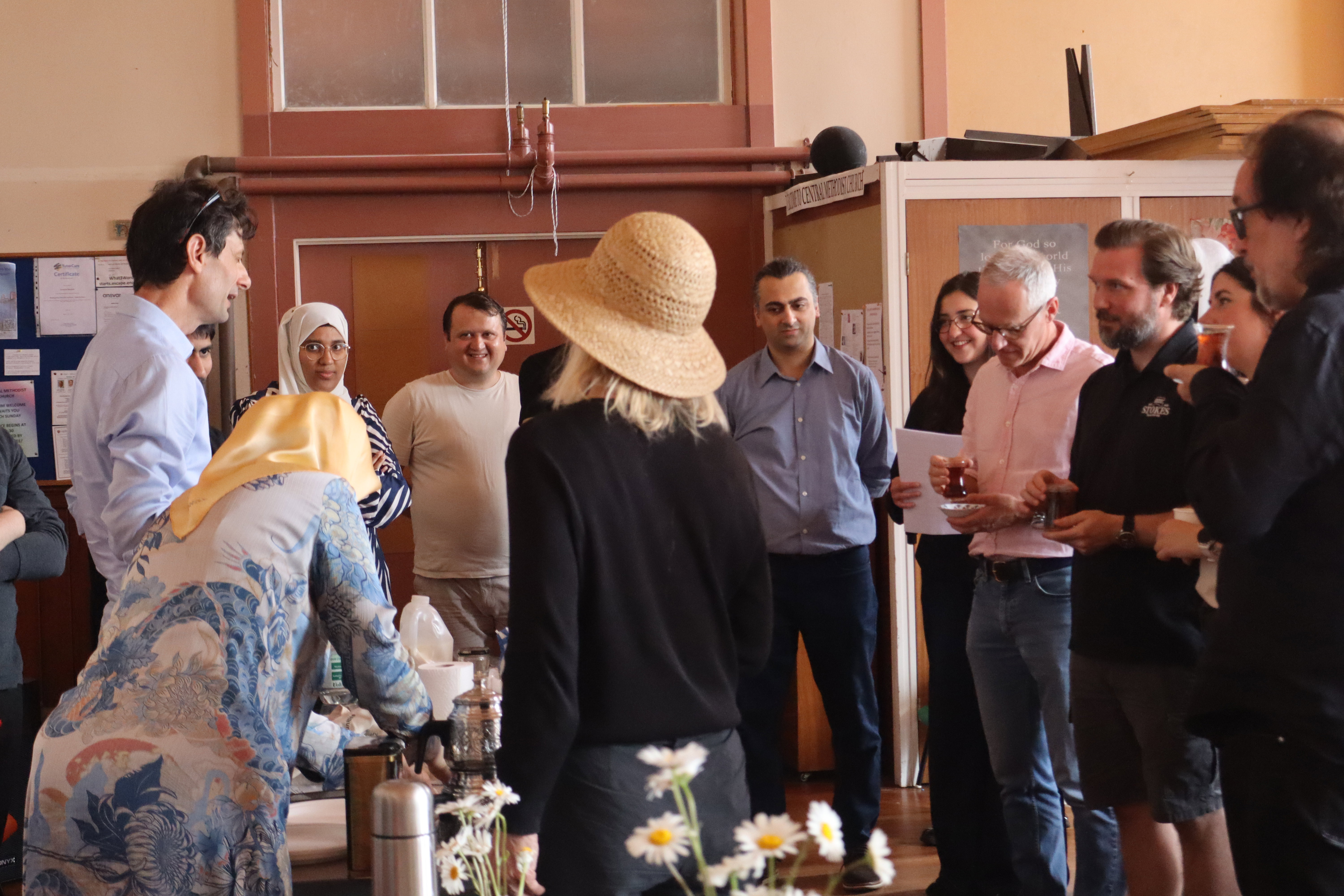 A group of judges and attended gathered around s tea station assessing teas during the international Tea Day celebration