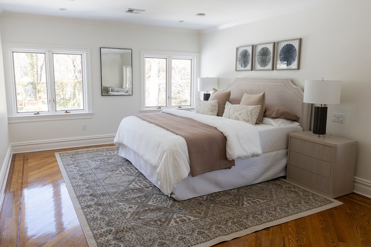 Primary bedroom with seating area staged by Stunning Spaces