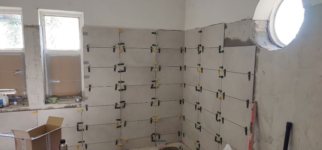 visszaburkolás közben társasházi kukatároló falburkolat Budapest 15 kerület