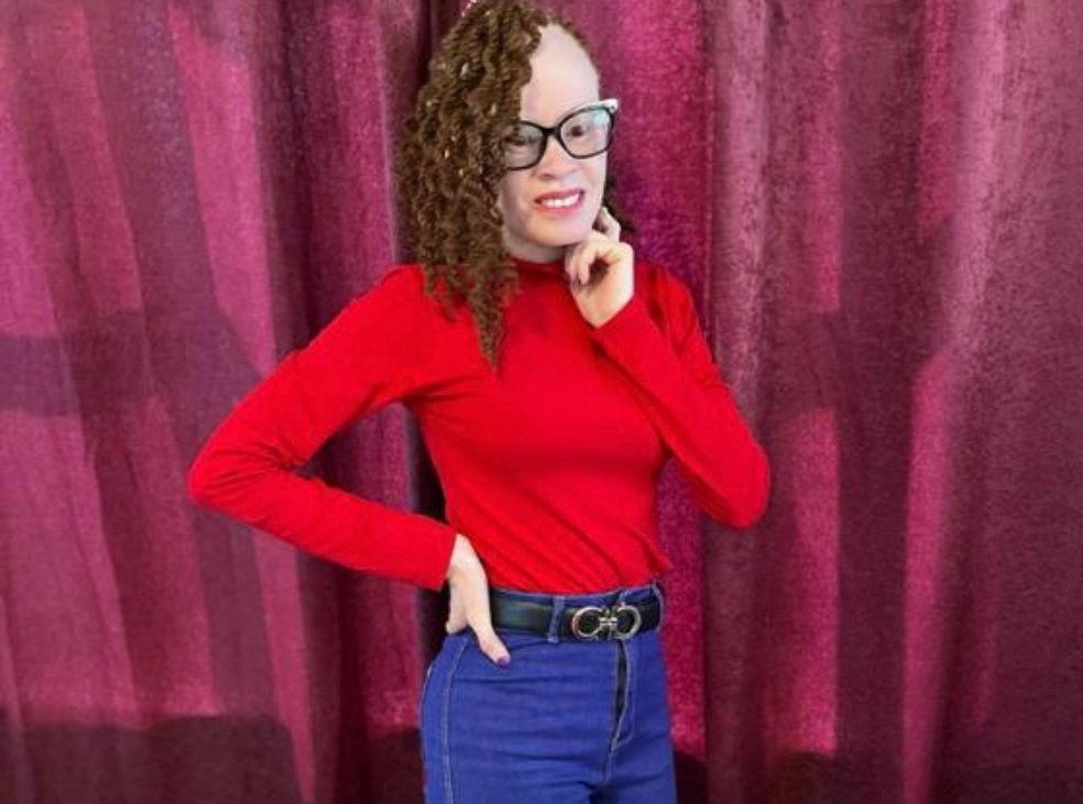 Faith Joseph wearing a red shaded blouse with braids on.