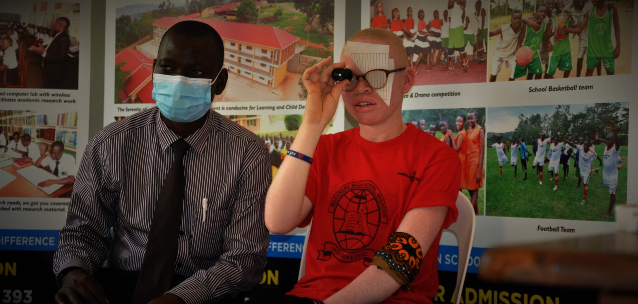 A picture of a doctor and a person with albinism taking eye tests.