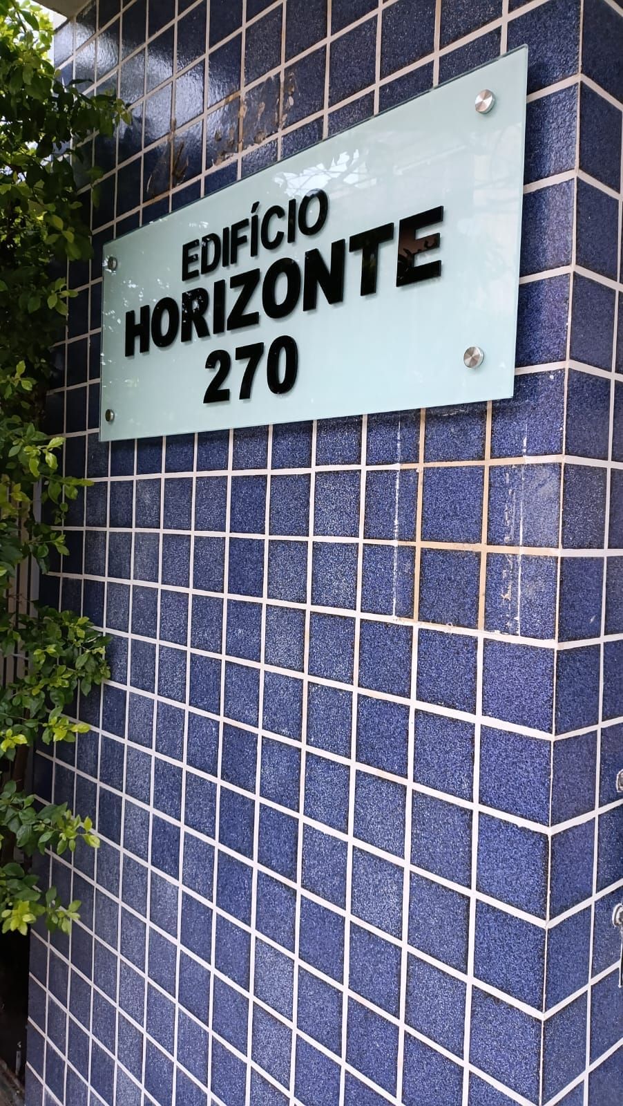 PLaca de vidro com arte adesivada e fixação por espaçadores cromados