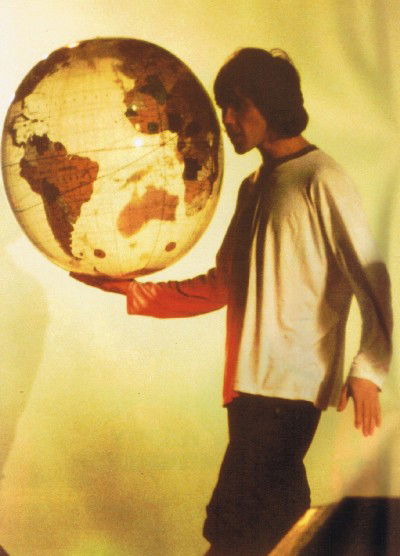 Ian Brown, the front man of The Stone Roses holding a globe at Spike Island in 1989