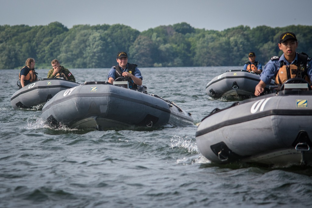 Quatre bateaux de type zodiac conduits par des cadets de la Marine.