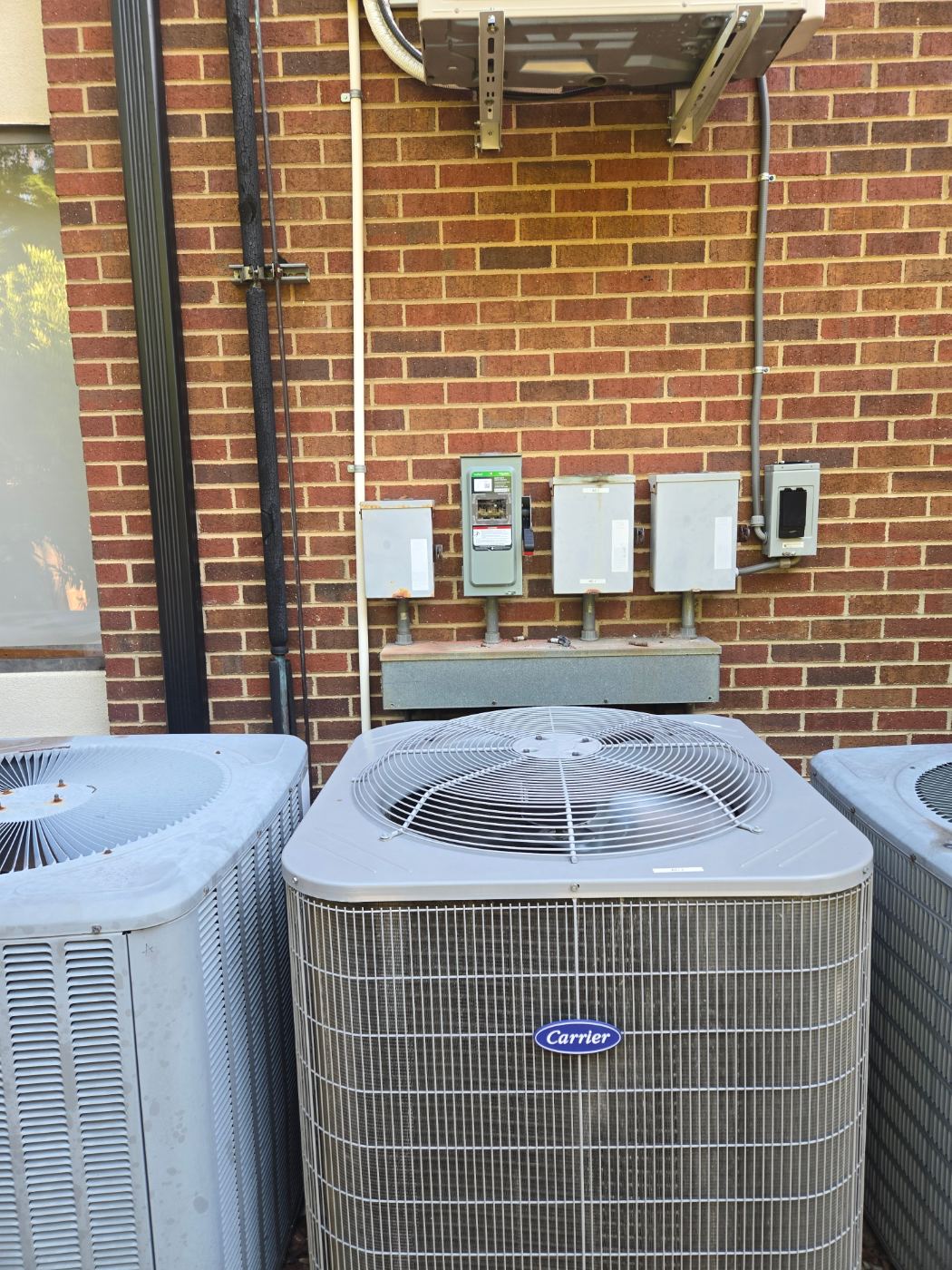 New HVAC disconnects wired outside a brick home by Stickler’s Electrical Service, electrician serving Hudson, NC
