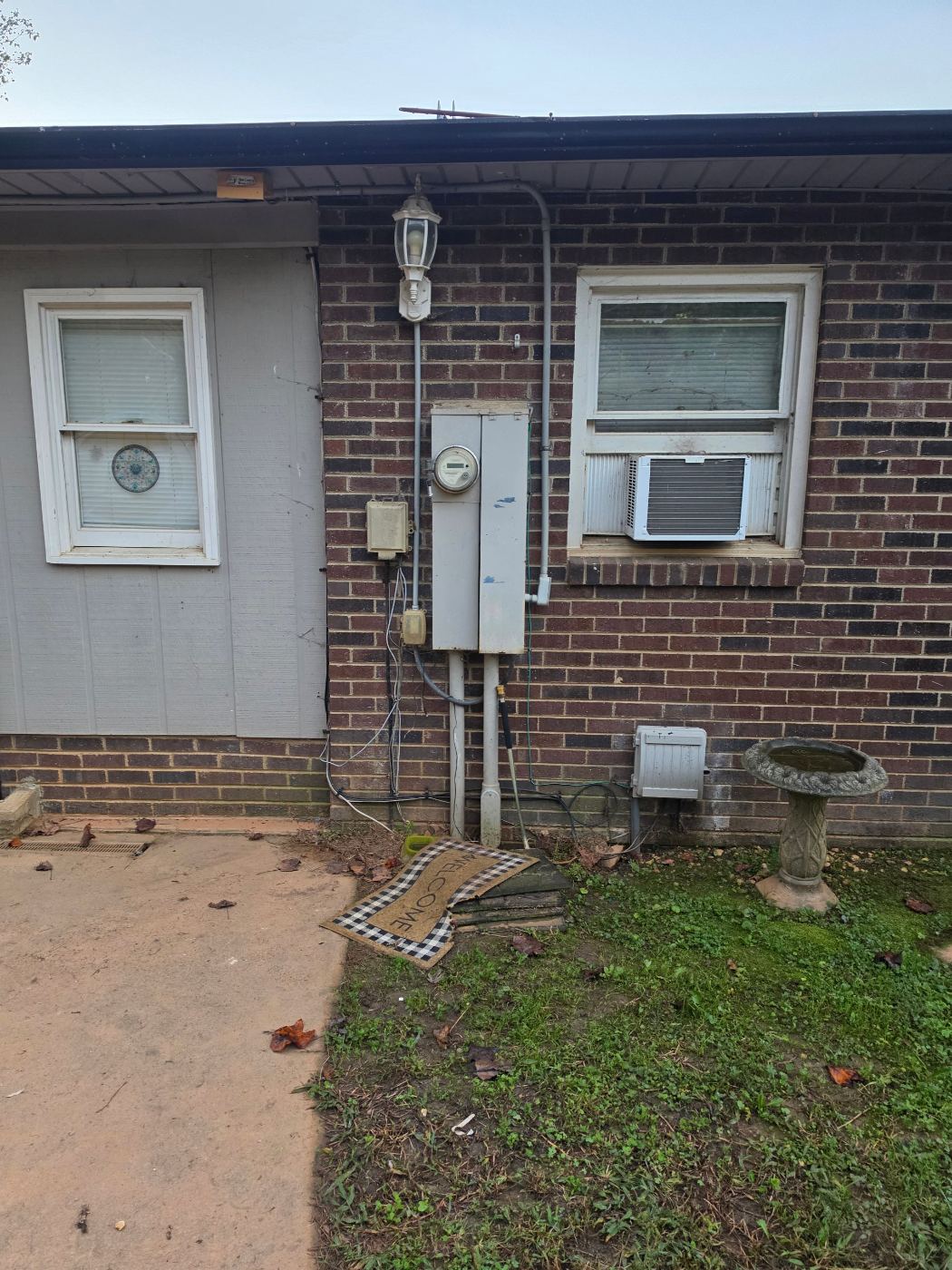 Old meter and service equipment on a brick home in Lenoir, NC before a service change by Stickler's Electrical Service