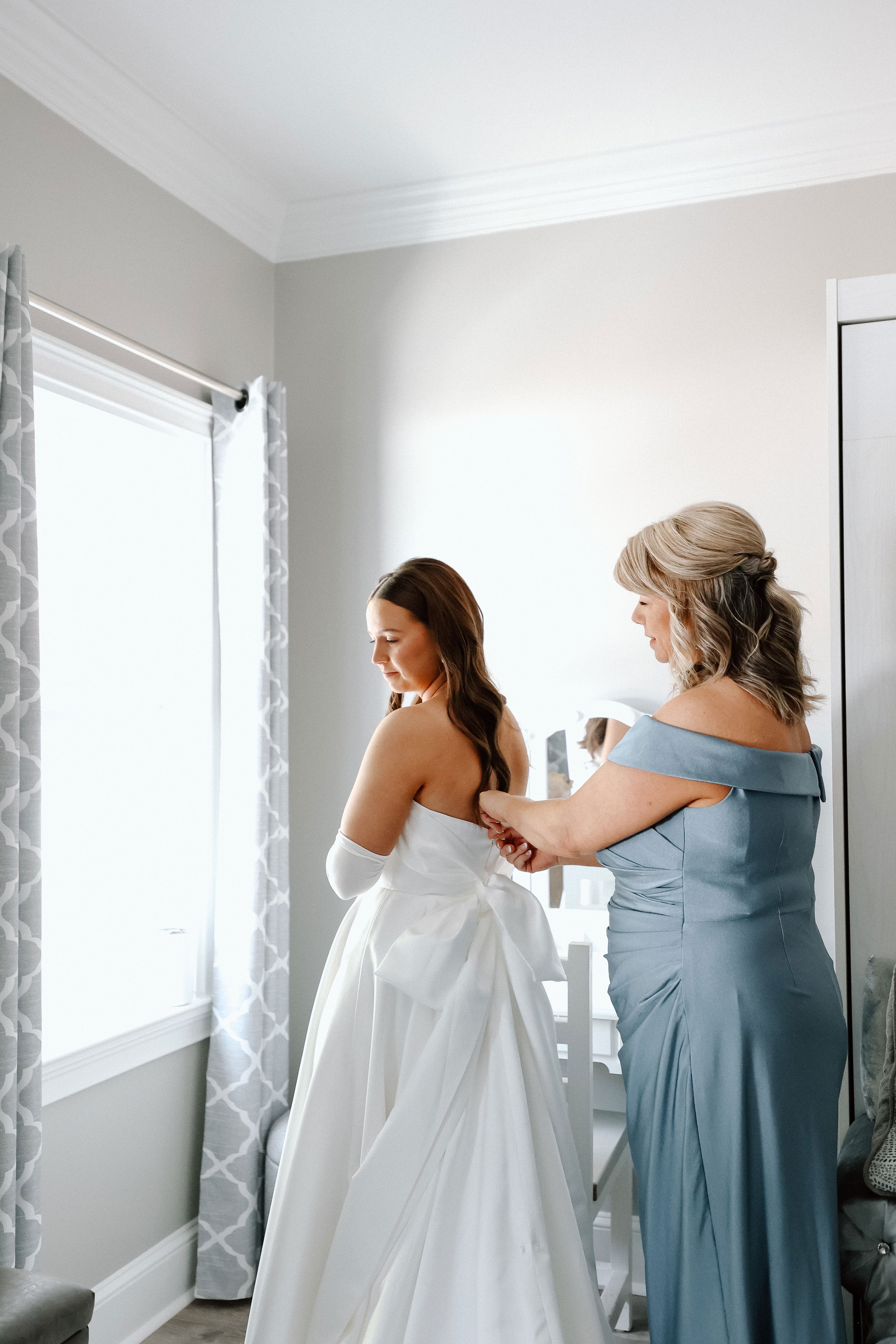 bride standing by window in wedding dress before ceremony in Monroe, GA near Athens, Georgia