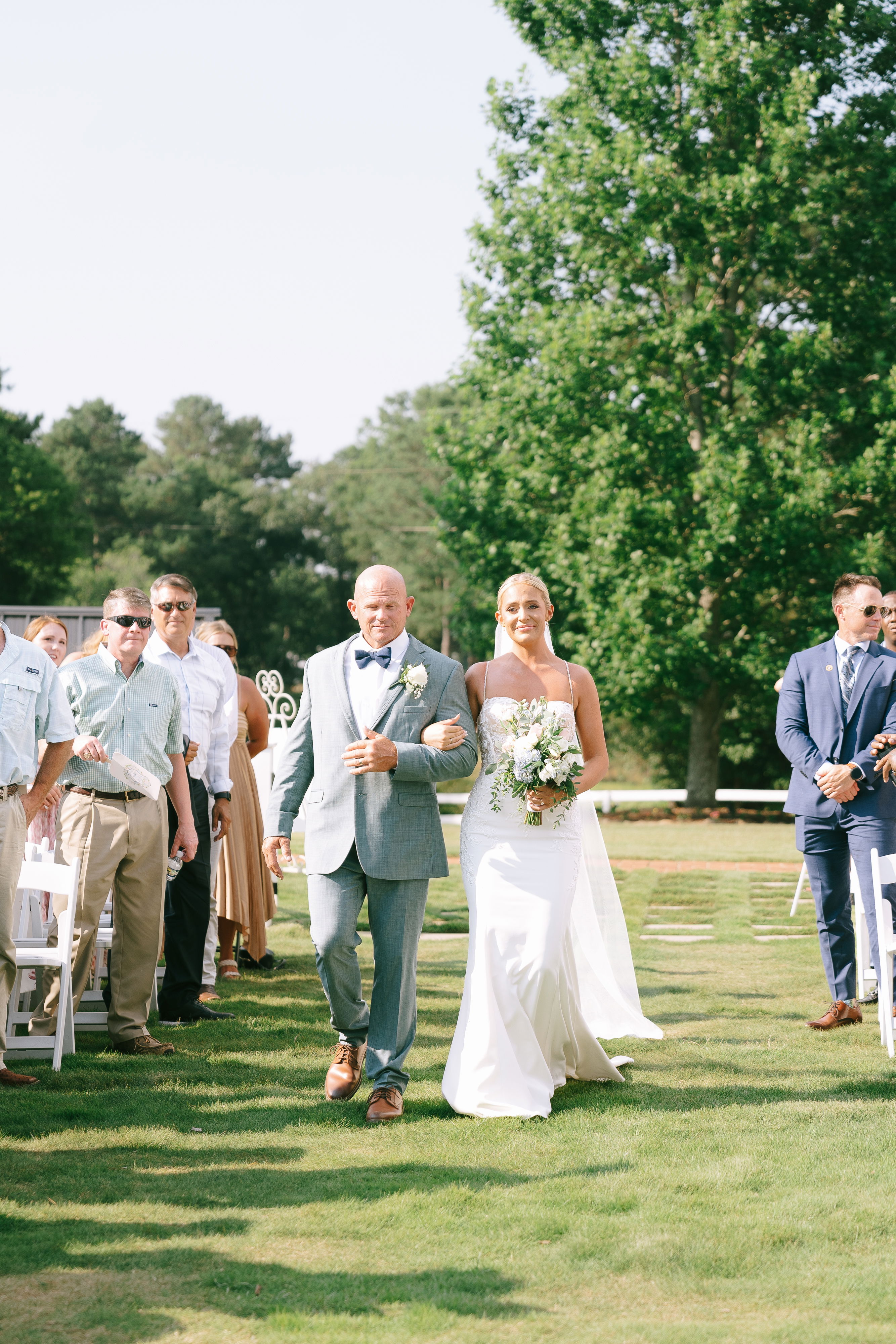 wedding ceremony in courtyard with church pews and white garden chairs in summer near Athens, Georgia