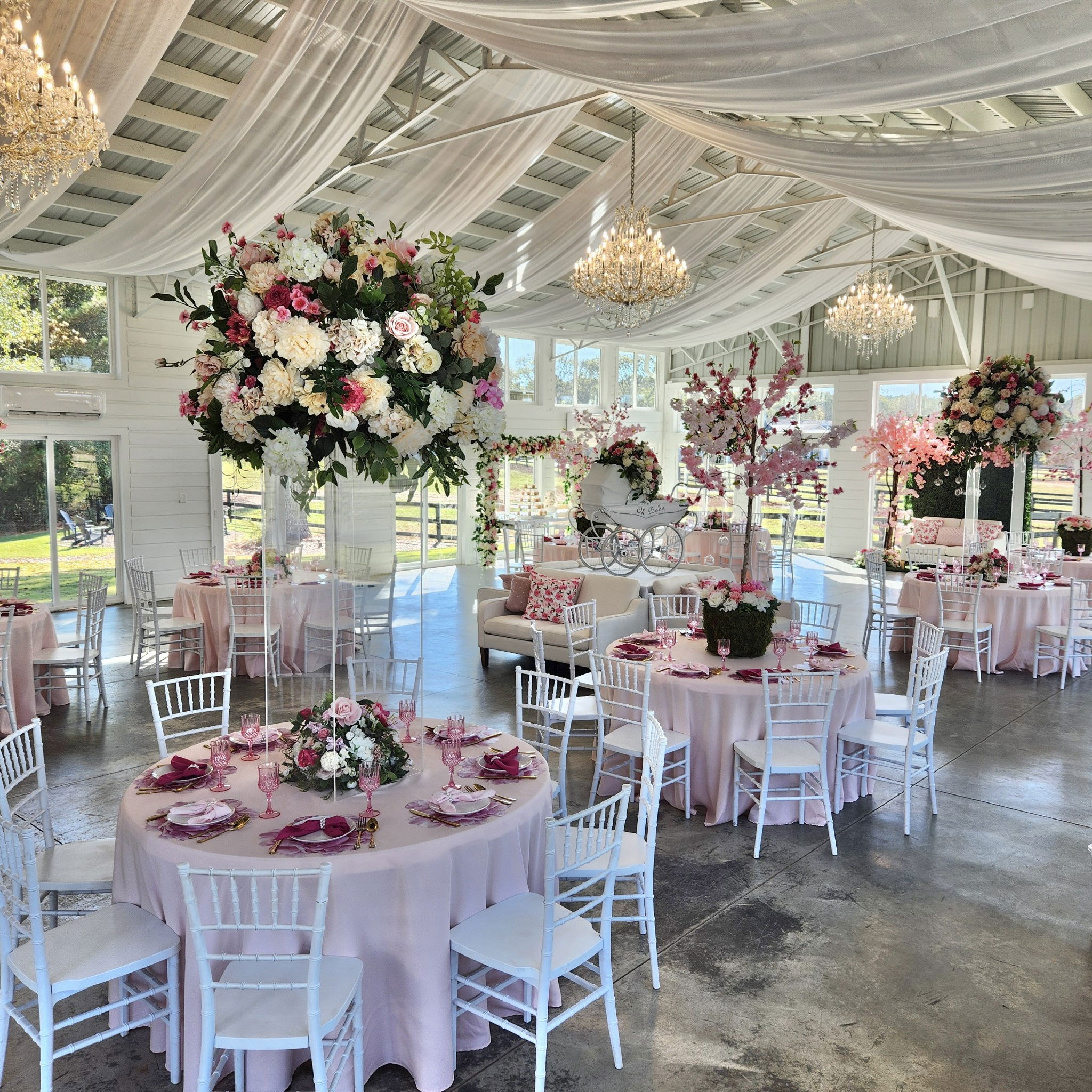 crystal chandeliers, draping, white chiavari chairs and expansive florals atop acrylic centerpieces in our bright airy reception room with views of countryside in Walton County, GA near Watkinsville, Georgia
