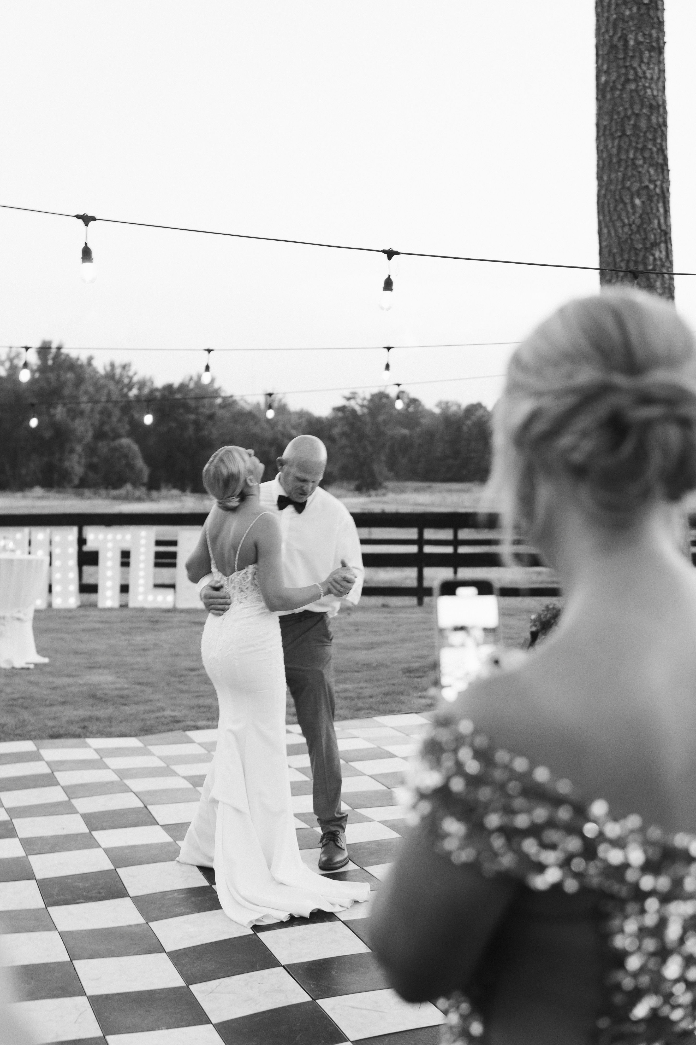 checkerboard outdoor dance floor with bistro lighting near gazebo with cocktail tables, marquis letters and horses near field of horses for summer wedding reception father daughter dance near Watkinsville, GA Oconee County, Georgia