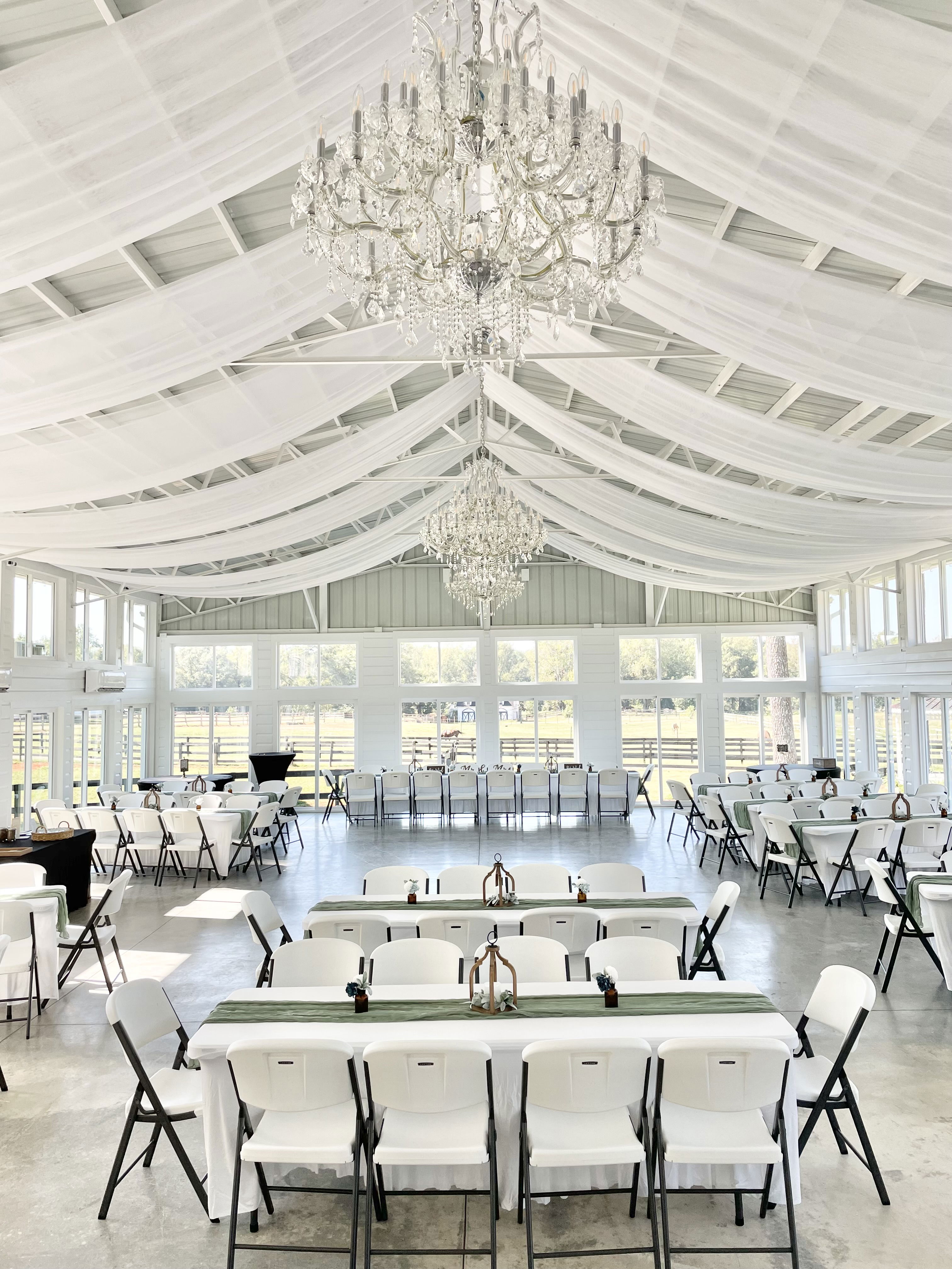 reception in bright airy space with crystal chandeliers, chiffon drapings, fairy lights, expansive views with windows in Monroe, GA near Watkinsville, Georgia