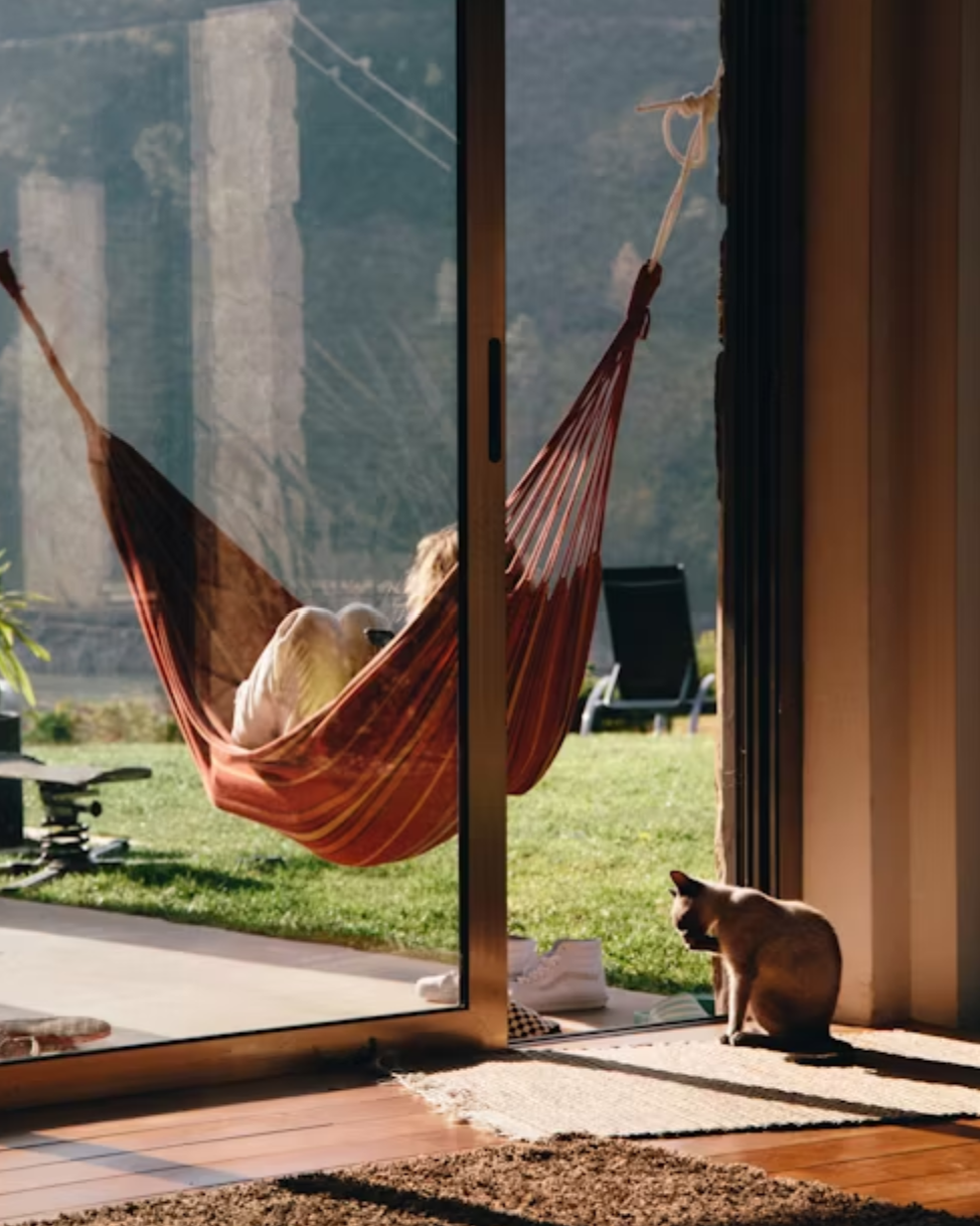 presenting benefits of hammock with a woman on it near the house