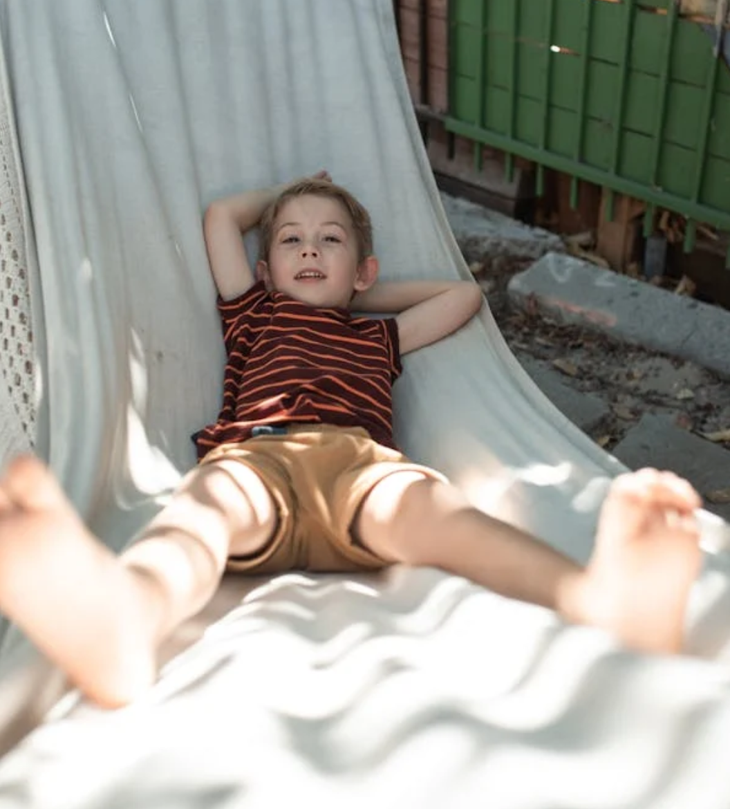 kid laying on hammock with legs raised