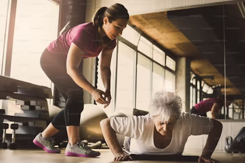 older women doing pushups young personal trainer helping senior woman workout in rehabilitation center