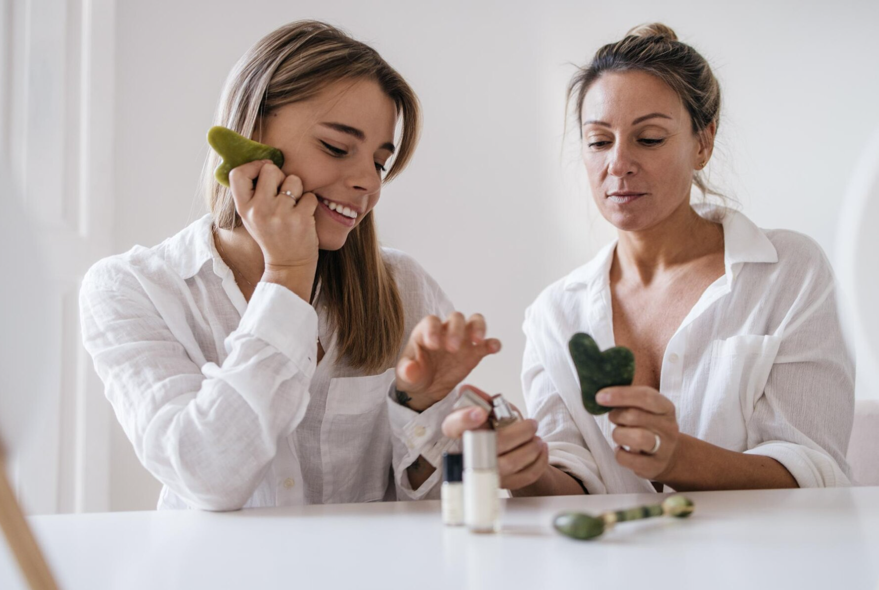 two caucasian blonde women different ages are tasting cosmetic product while sitting white background skin care hydration concept