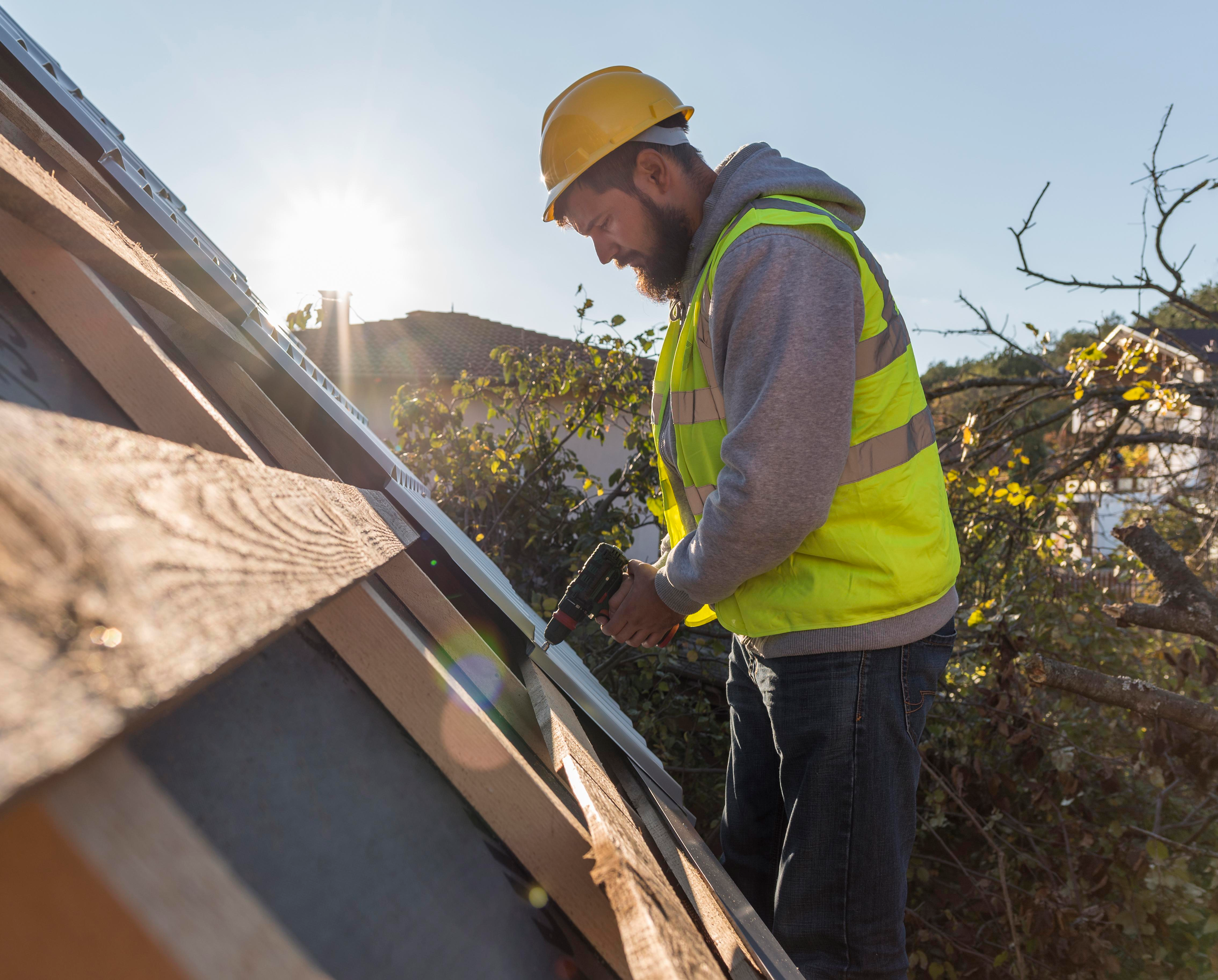 man working roof with drill