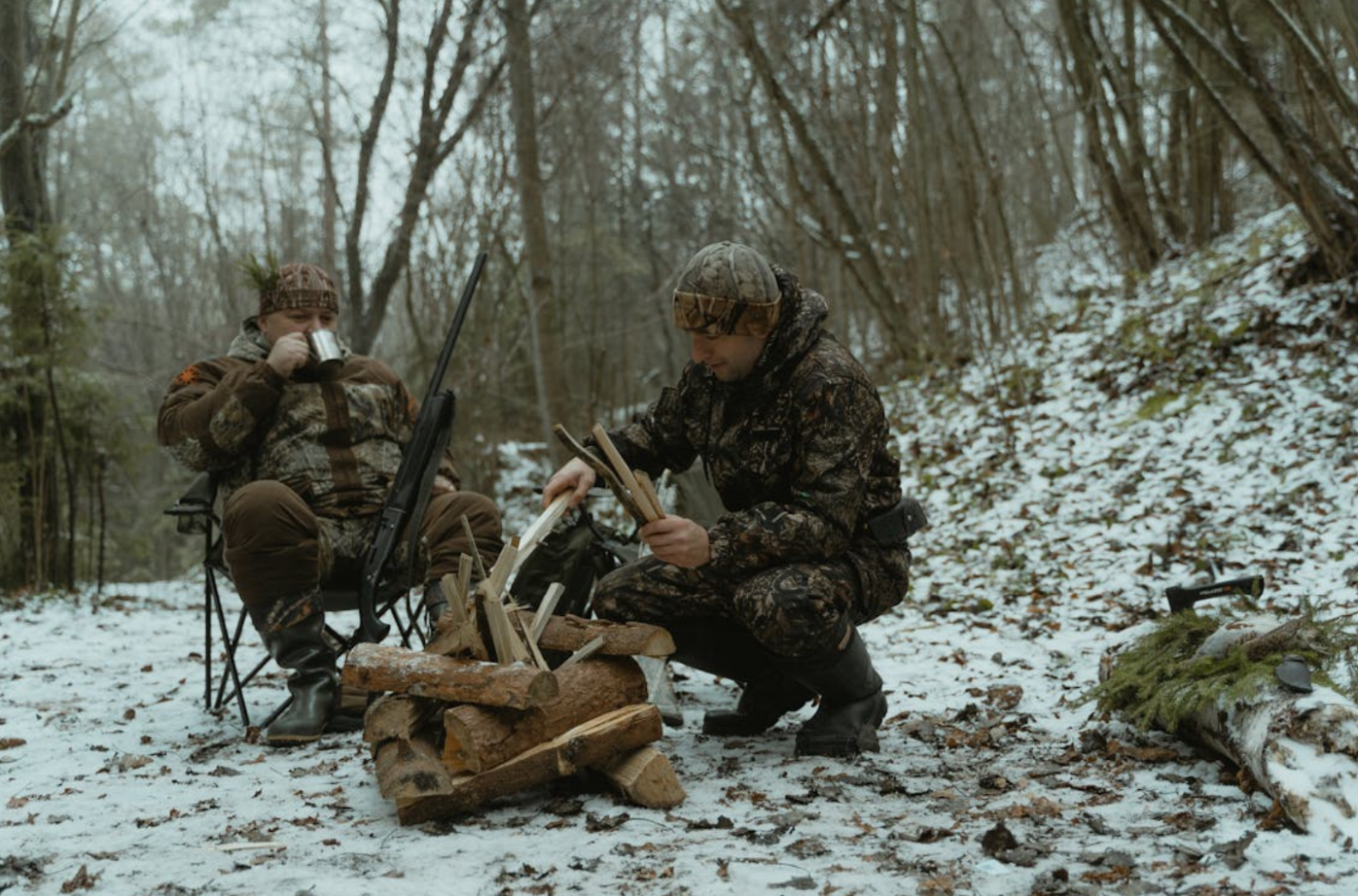 two man making fire in the woods