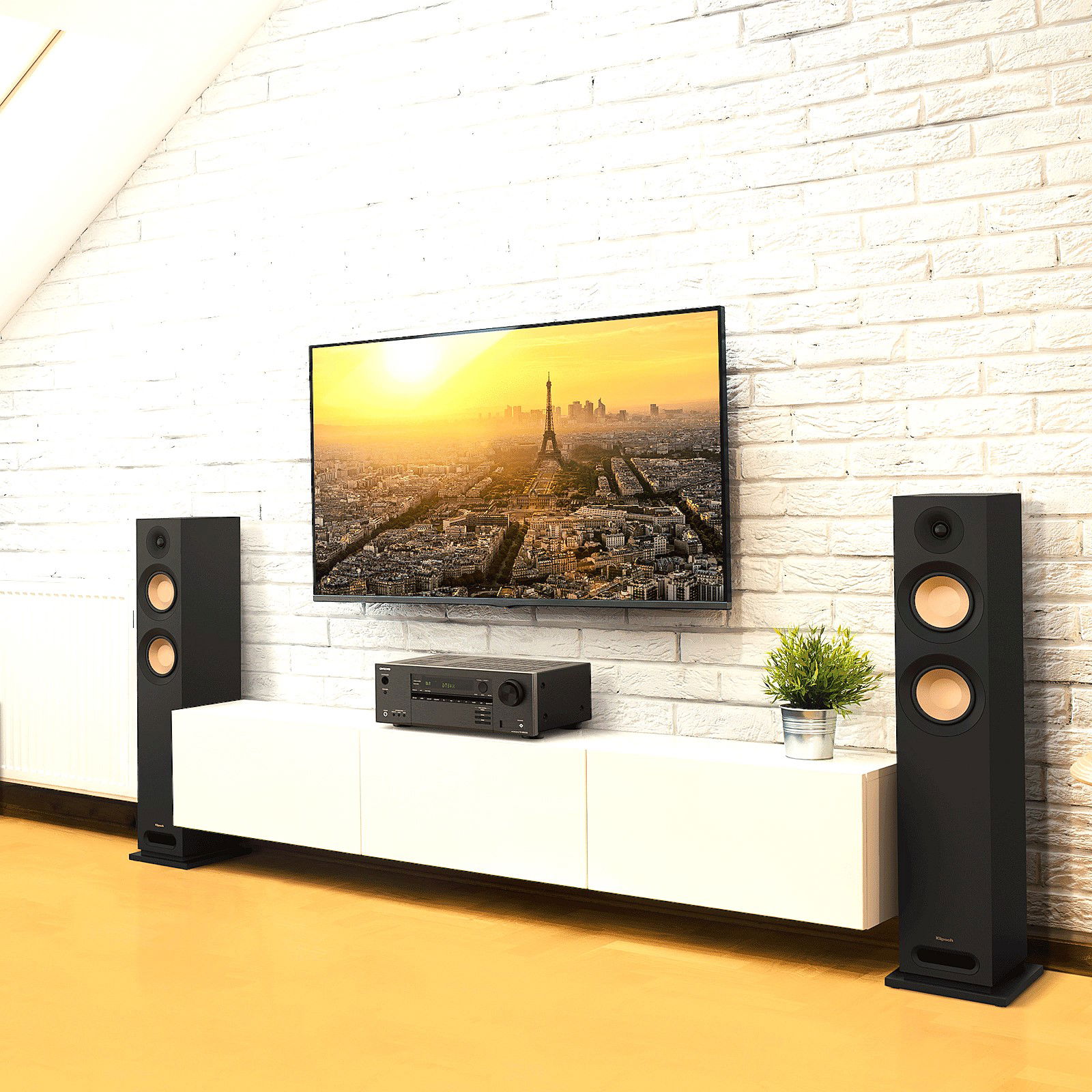 תמונת אווירה של שידה לבנה עם זוג רמקולים Klipsch רצפתיים מונחים משני צידיה, רסיבר Onkyo TX-NR6100 מונח עליה וטלויזיה חכמה תלויה על הקיר