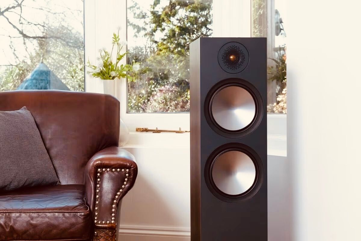 תמונת אווירה של רמקול Monitor Audio Bronze 500 6G עומד על יד ספת עור חומה בסלון