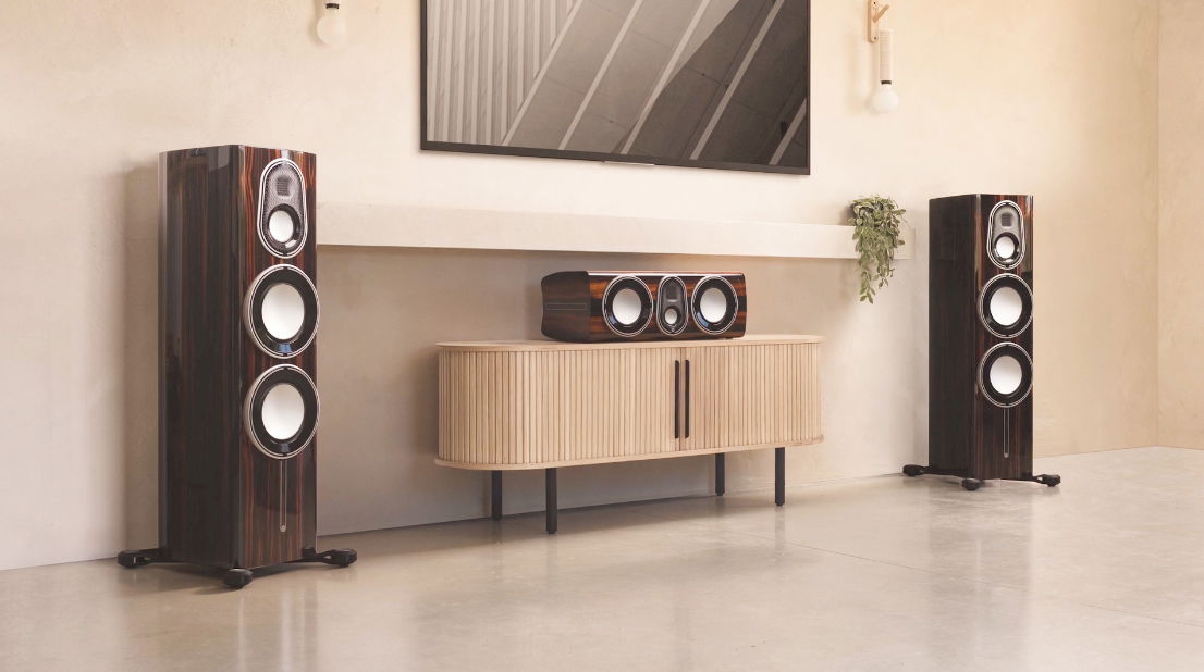 תמונה של זוג רמקולים וסנטר תואם Monitor Audio Platinium 300 3G מוצבים בסלון סביב טלויזיה