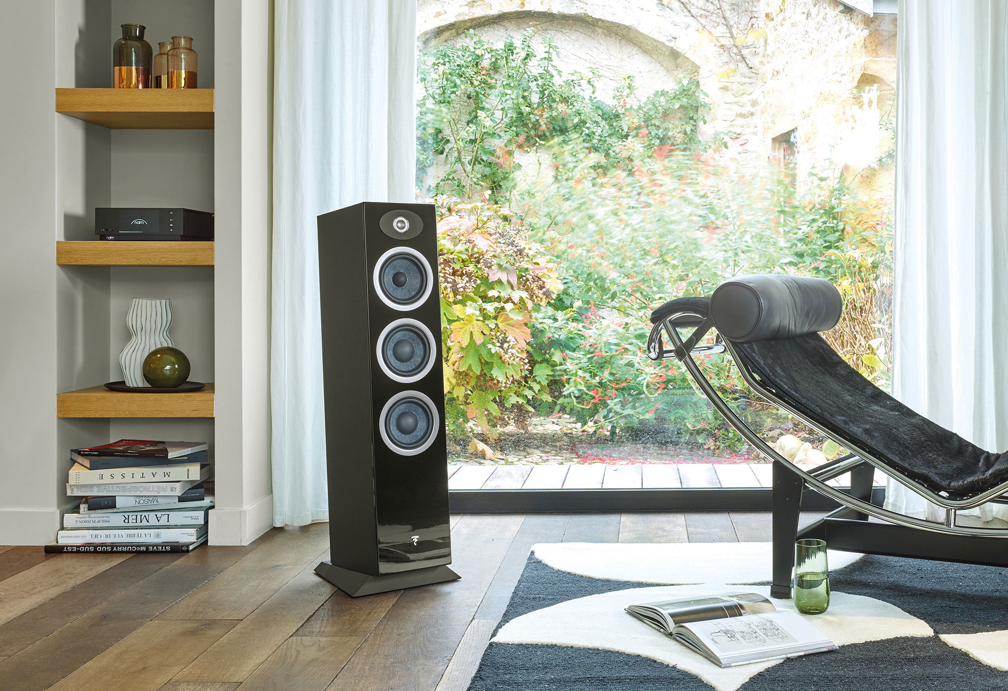 תמונה של רמקול רצפתי שחור Focal Theva N°2 עומד בסלון על יד כורסא