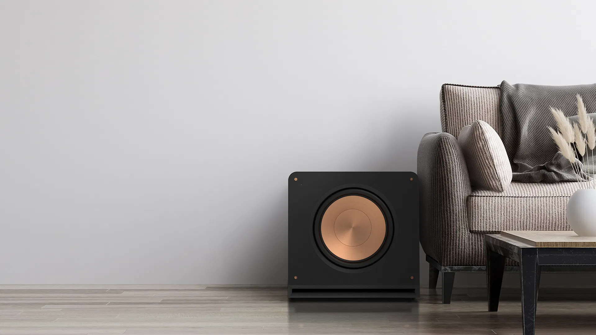 תמונת אווירה של הסאב Klipsch RP-1400SW מונח על יד ספה בסלון