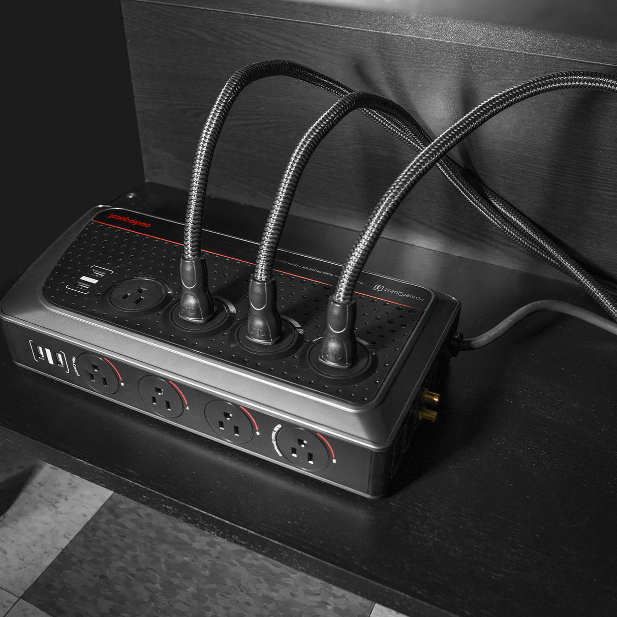מנהל המתח AudioQuest PowerQuest 3 שוכב ומחובר לארבעה כבלי חשמל
