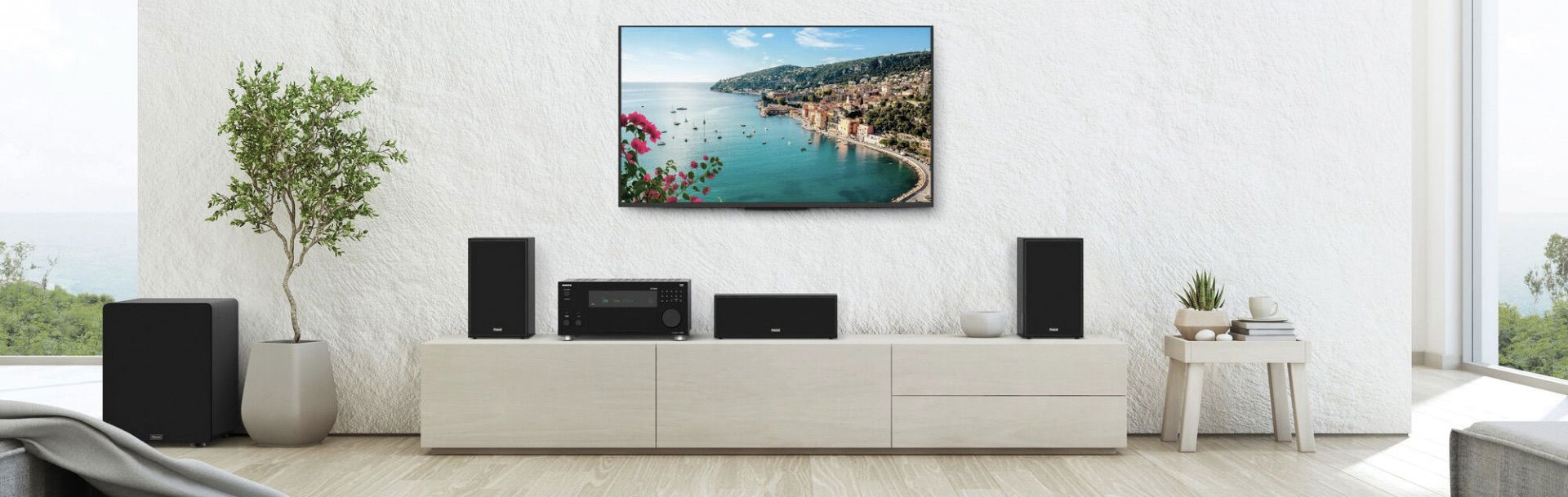 Magnat Monitor S12C רמקול סנטר מגנט מונח על שידה בסלון יחד עם מערכת שלמה כולל רסיבר