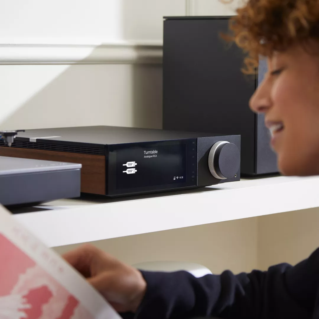 בחורה מפעילה את המגבר רסיבר סטרימר היי אנד קמברידג' אודיו Cambridge Audio EVO 150 בצילום מלמעלהמגבר רסיבר סטרימר היי אנד קמברידג' אודיו Cambridge Audio EVO 75 בנגיעה בכפתור הווליום