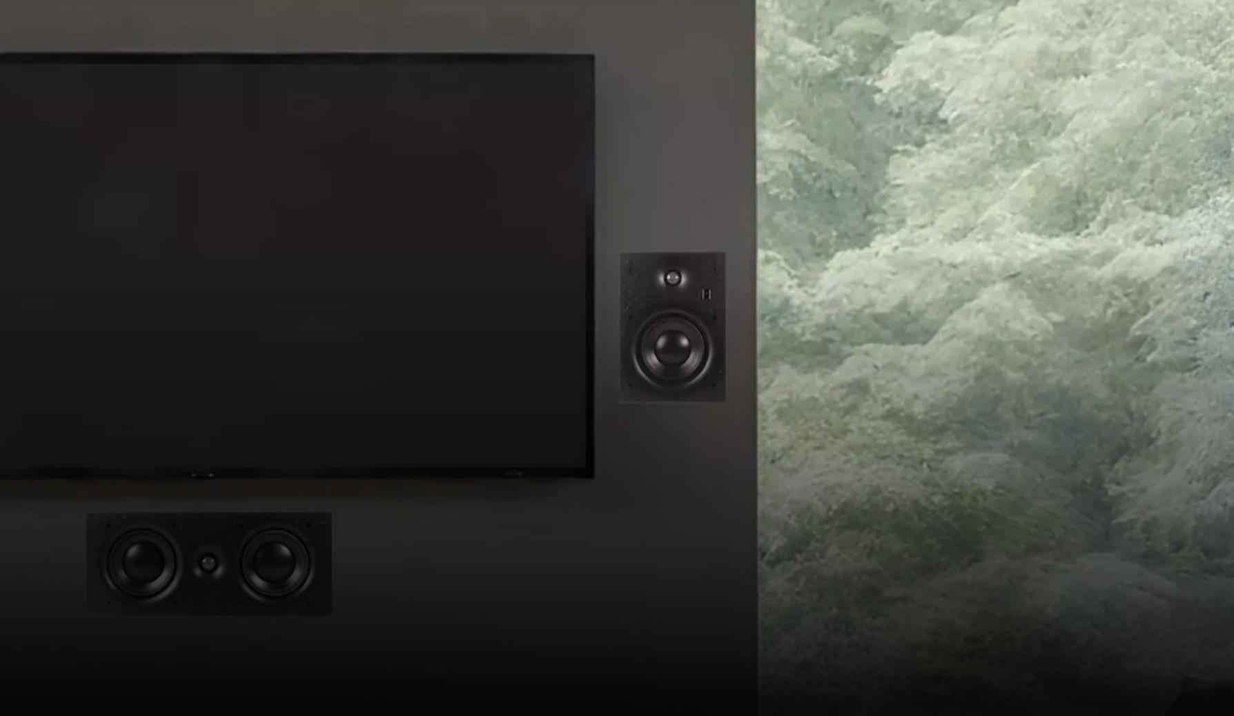 קיר טלוויזיה בסלון מודרני עם זוג רמקולים שקועים מוראל Morel MHW600 משני צידי הטלוויזיה ורמקול סנטר תואם מותקן שקוע מתחתיה