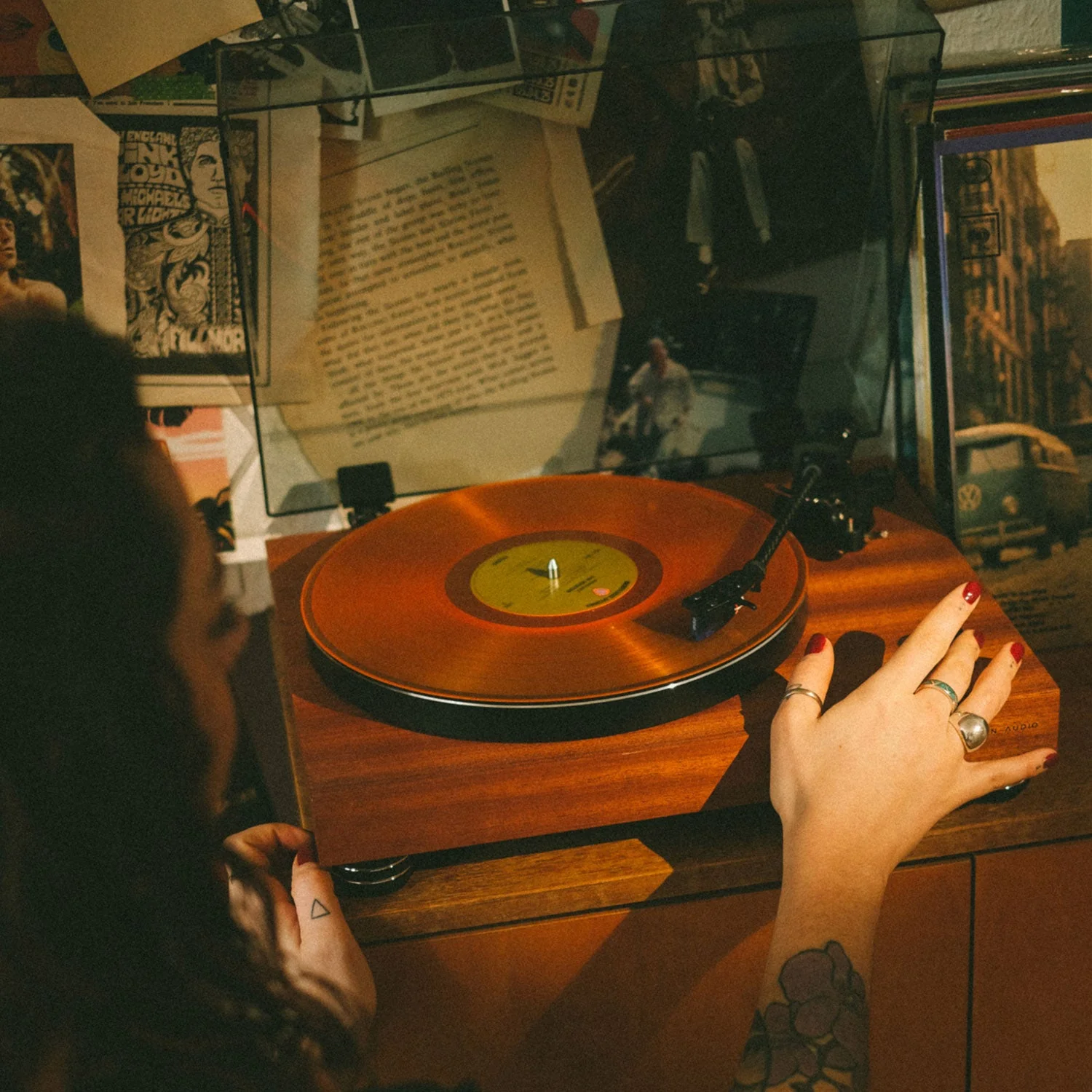 פטיפון ארגון Argon Audio TT-4 MK2 בגימור מופעל על ידי מישהי ויושב על שידה בצילום מלמעלה