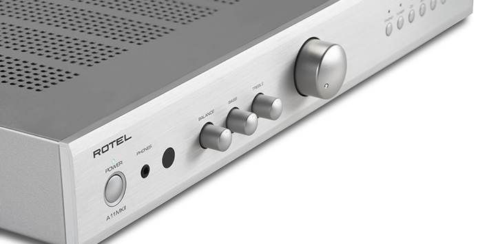 תקריב על חזית מגבר Rotel A11MkII בגימור כסף המציג את כפתור ההפעלה, כניסת האוזניות ובוררי ה-Balance, Bass ו-Treble