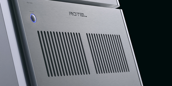 חזית מגבר כוח סטריאו Rotel RB-1590 בגימור כסף – תקריב על פאנל אלומיניום מוברש עם כפתור הפעלה מואר ופתחי אוורור כפולים