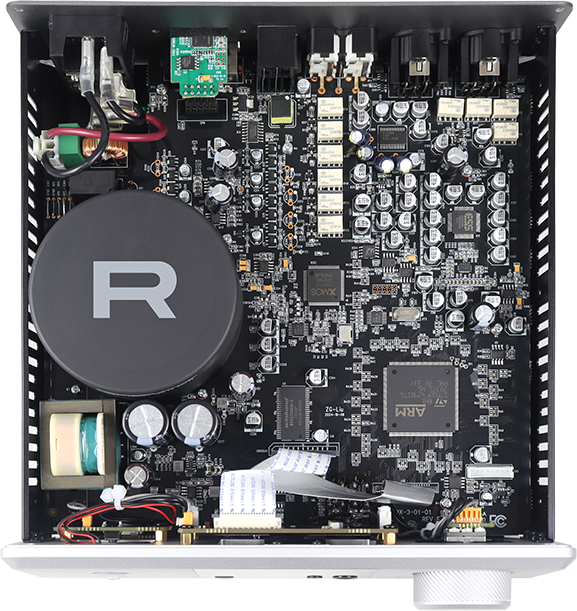 מבט פנימי על ה-Rotel DX-3, המציג הנדסה אודיופילית: שנאי טבעתי גדול עם לוגו R בולט ומעבד ARM במרכז לוח המעגלים