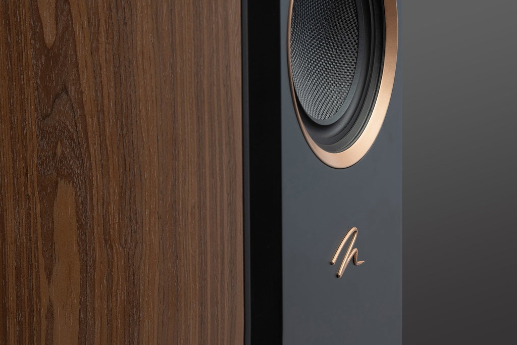 תקריב על חלקו העליון של רמקול רצפתי Martin Logan Motion XT F200 בגימור עץ ואגוז המציג את דרייבר המיד-ריינג' עם טבעת נחושת מלוטשת