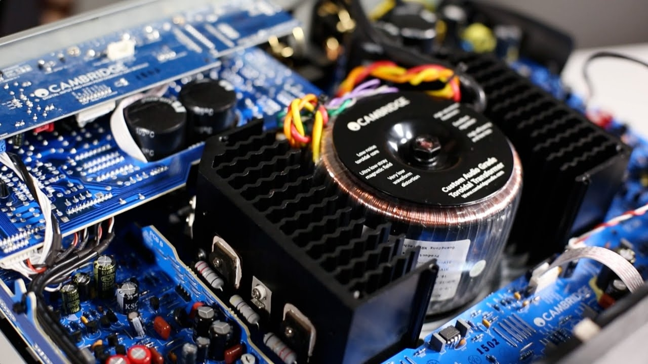תמונה של חלקו הפנימי של מגברהסטריאו Cambridge Audio CXA61 כשהוא פתוח עם כל חלקי האלקטרוניקה חשופים כולל השנאי הטורואידי שלו