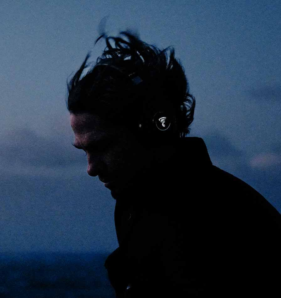 אוזניות אלחוטיות עם ביטול רעשים פוקל Focal Bathys על מישהו שהולך לבדו על שפת הים