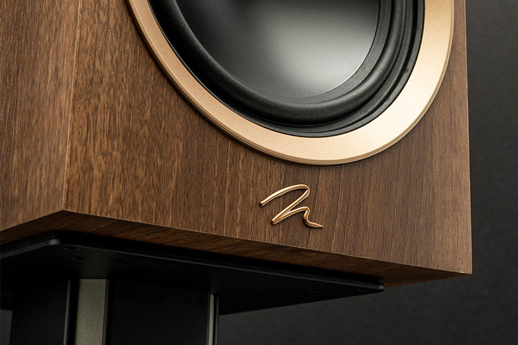 תקריב על רמקול Martin Logan בגימור עץ ואלנט יוקרתי, המציג את הלוגו המוזהב ואת טכנולוגיית הטוויטר הייחודית לצליל צלול ומפורט