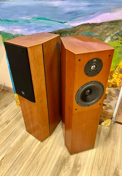 רמקולים רצפתיים JBL XTi40 בצבע עץ מבריק עומדים ללא גריל זה לצד זה במעט זוית פתוחה ובצילום מלמעלה