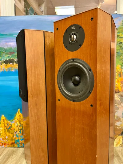 רמקולים רצפתיים JBL XTi40 בצבע עץ מבריק עומדים ללא גריל זה לצד זה במעט זוית פתוחה בצילום קרוב חזיתי