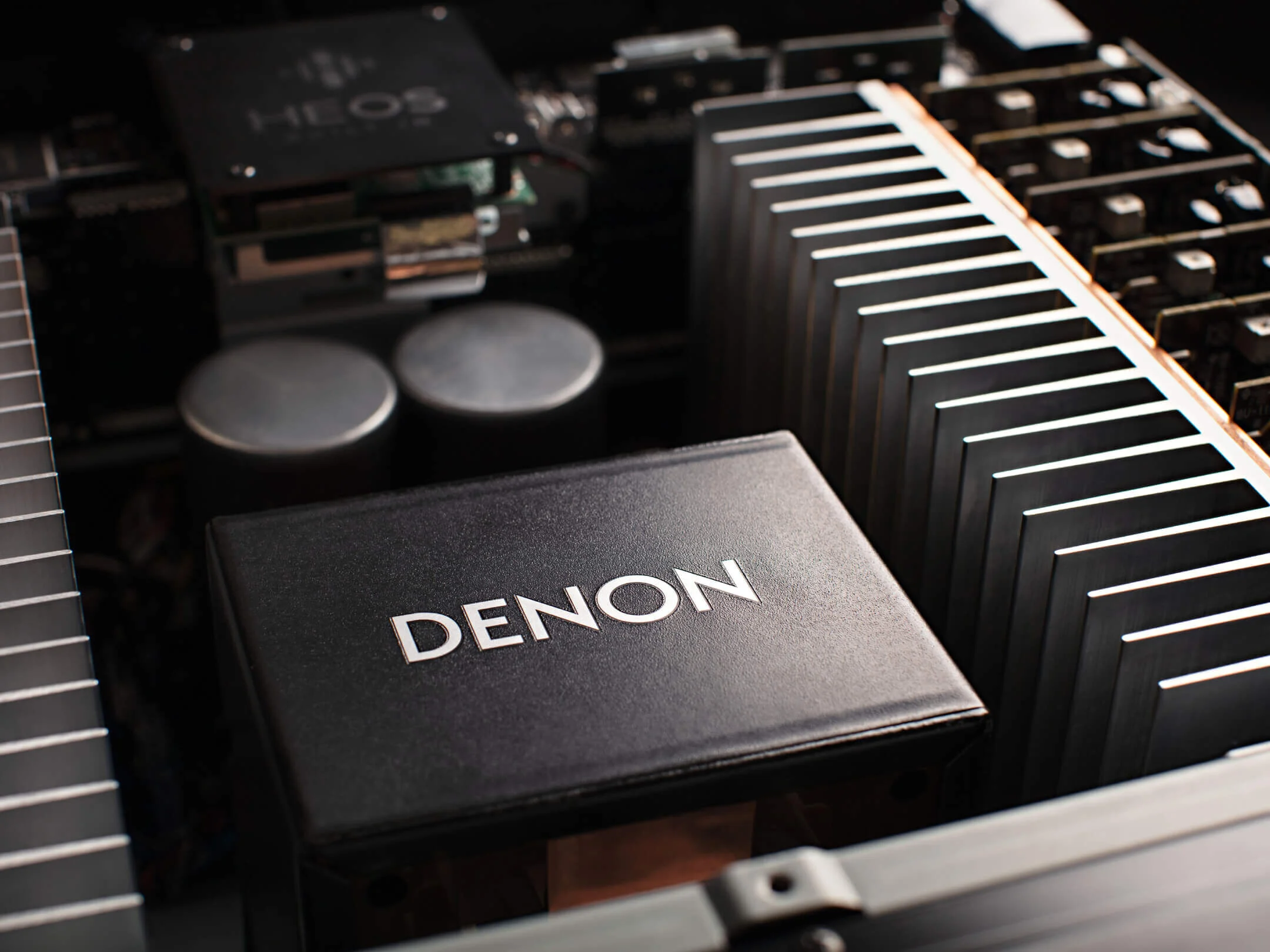 מגבר קולנוע ביתי דנון Denon AVC-A1H בצילום תקריב של המגר פתוח ללא מכסה המארז עם תקריב על ספק הכוח הגדול והמקורי של דנון