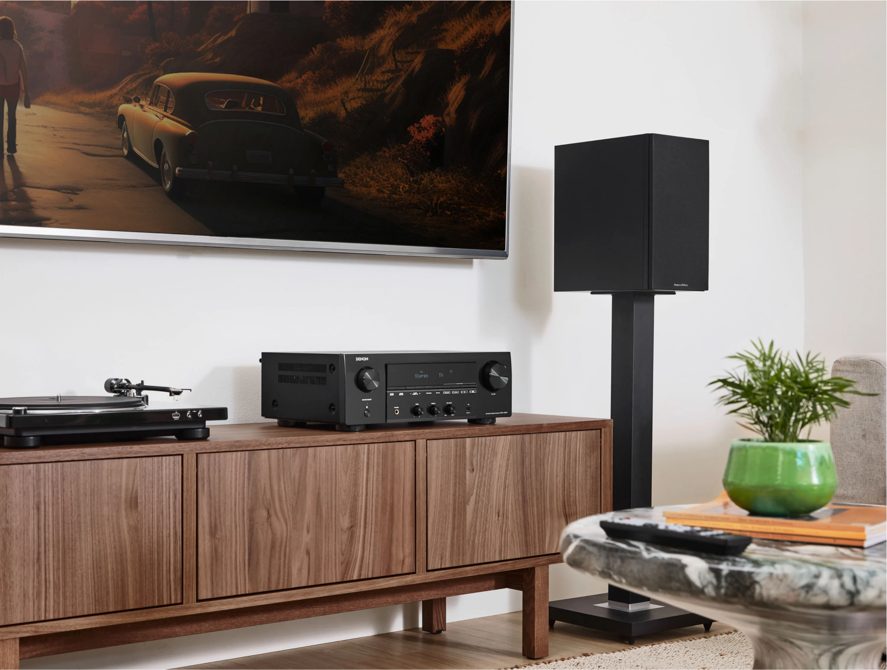 רסיבר רשת סטרימר דנון Denon DRA-900H מונח על שידת עץ כחלק ממערכת בסלון