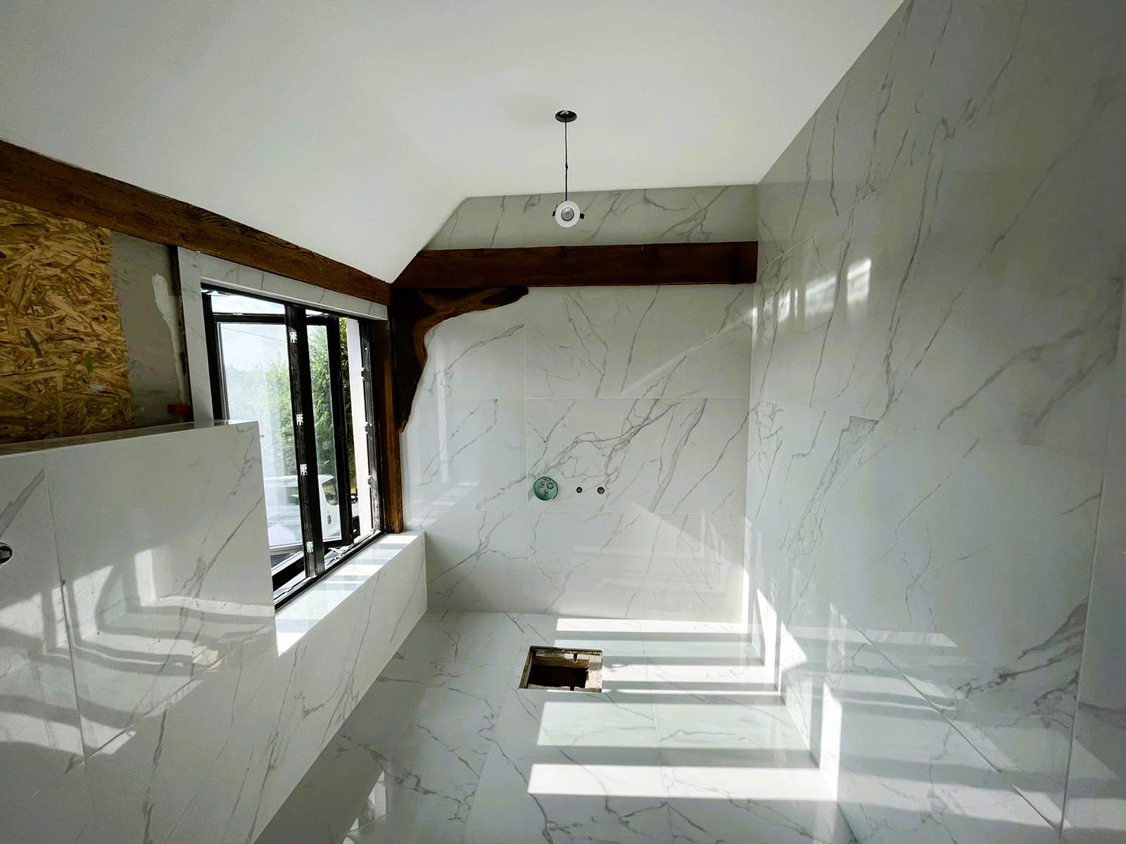 Intricate cuts in large format porcelain to the wooden beams of a barn in High Ongar