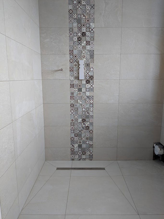 Mosaic feature in bathroom wall by Hunter Tiling Ltd in Chelmsford