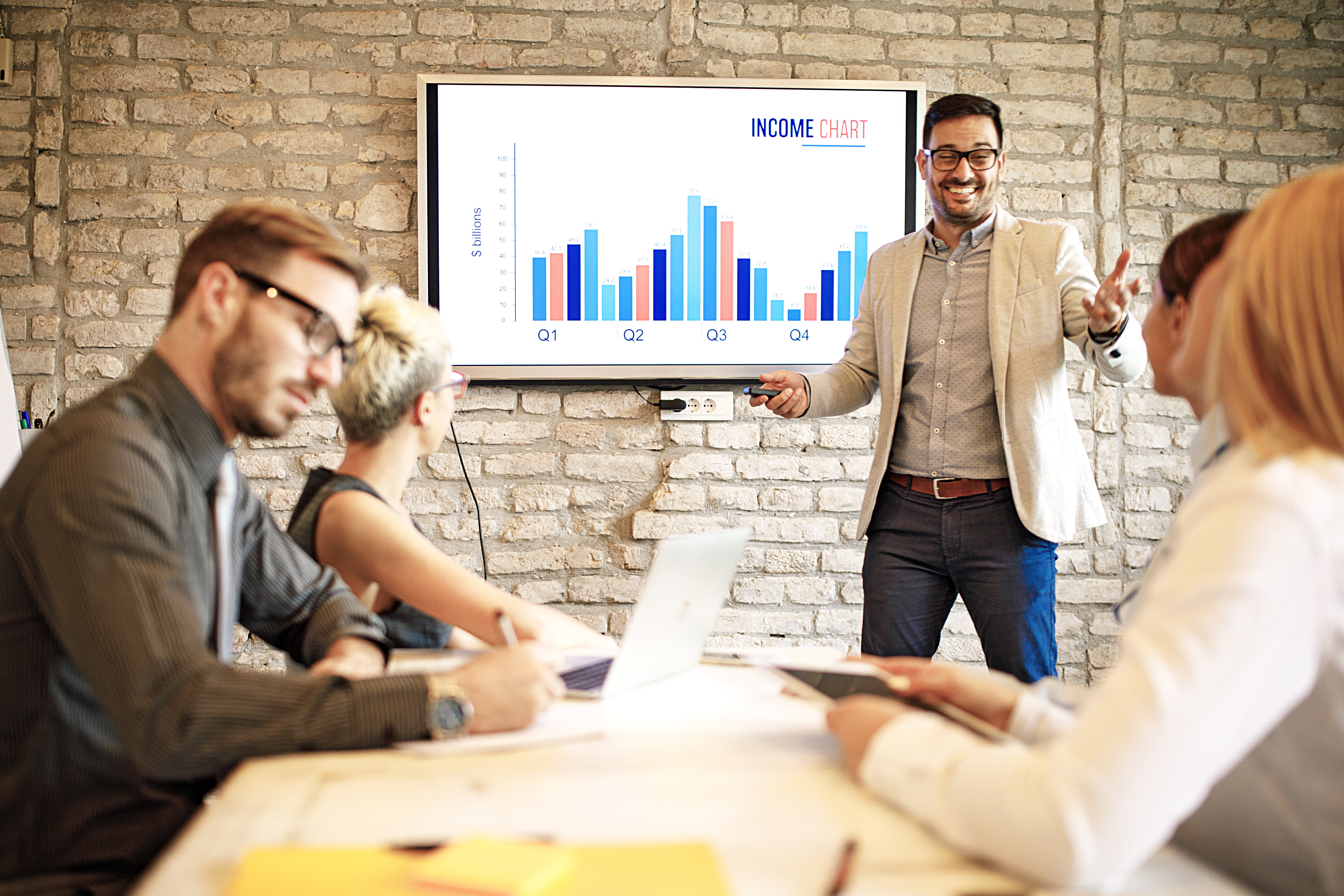 איש מכירות מציג בפני לקוח במשרד גרף ויזואלי הממחיש את ה-ROI (החזר ההשקעה) המיידי, כשהתמחור נמצא ברקע כפרט משני.