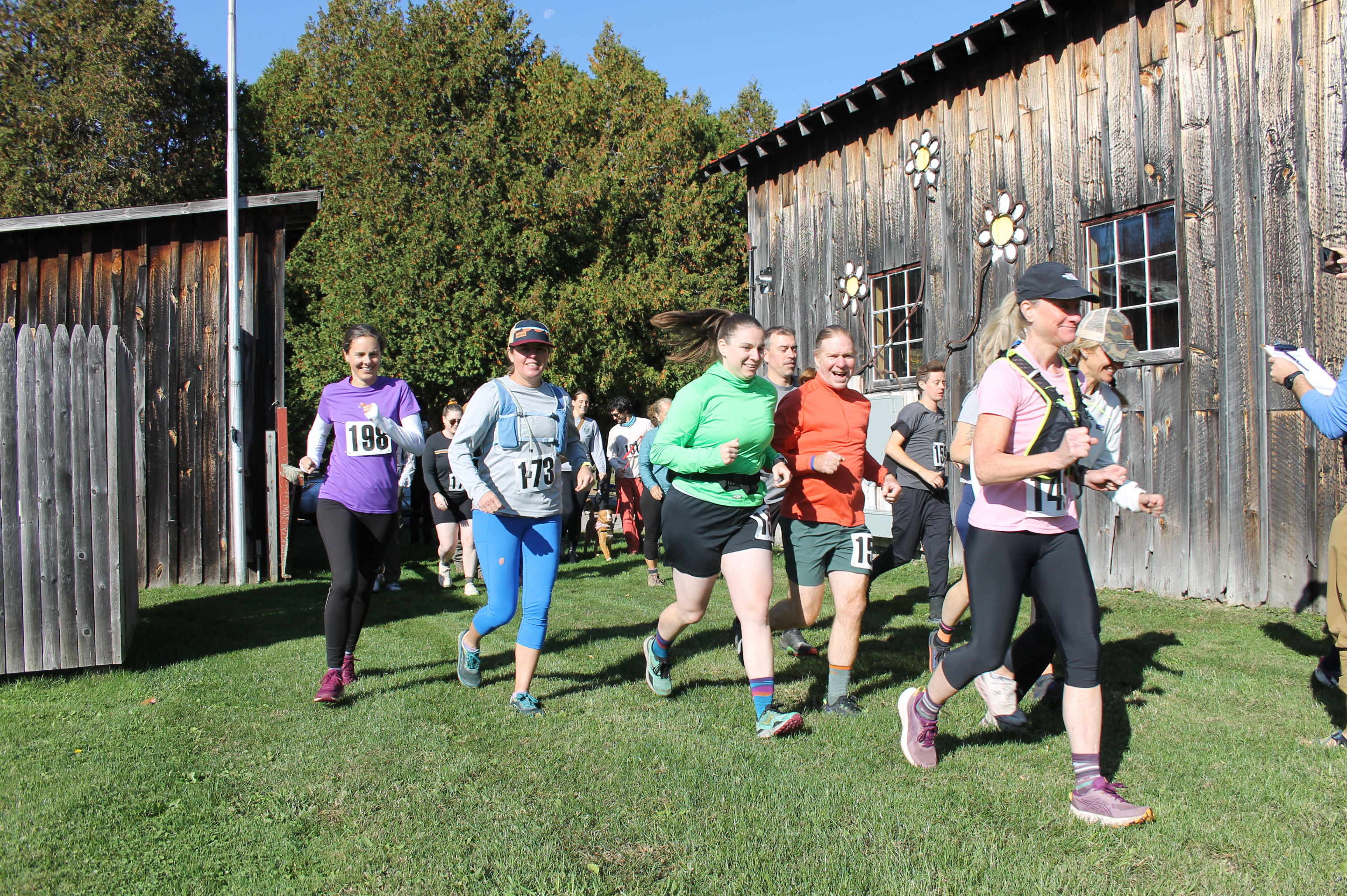 Racers starting off in front of a barn