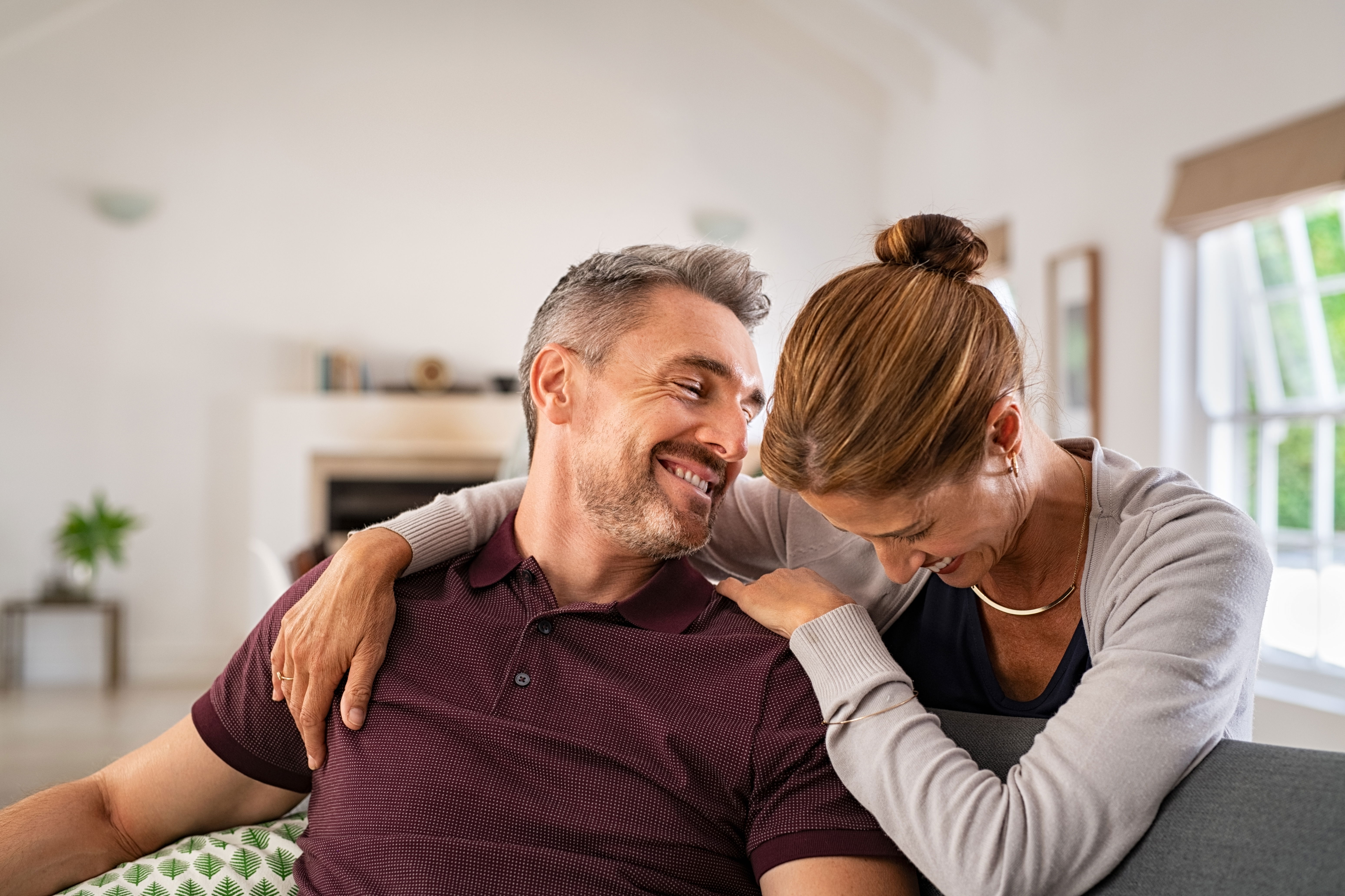 Couple laughing on a sofa