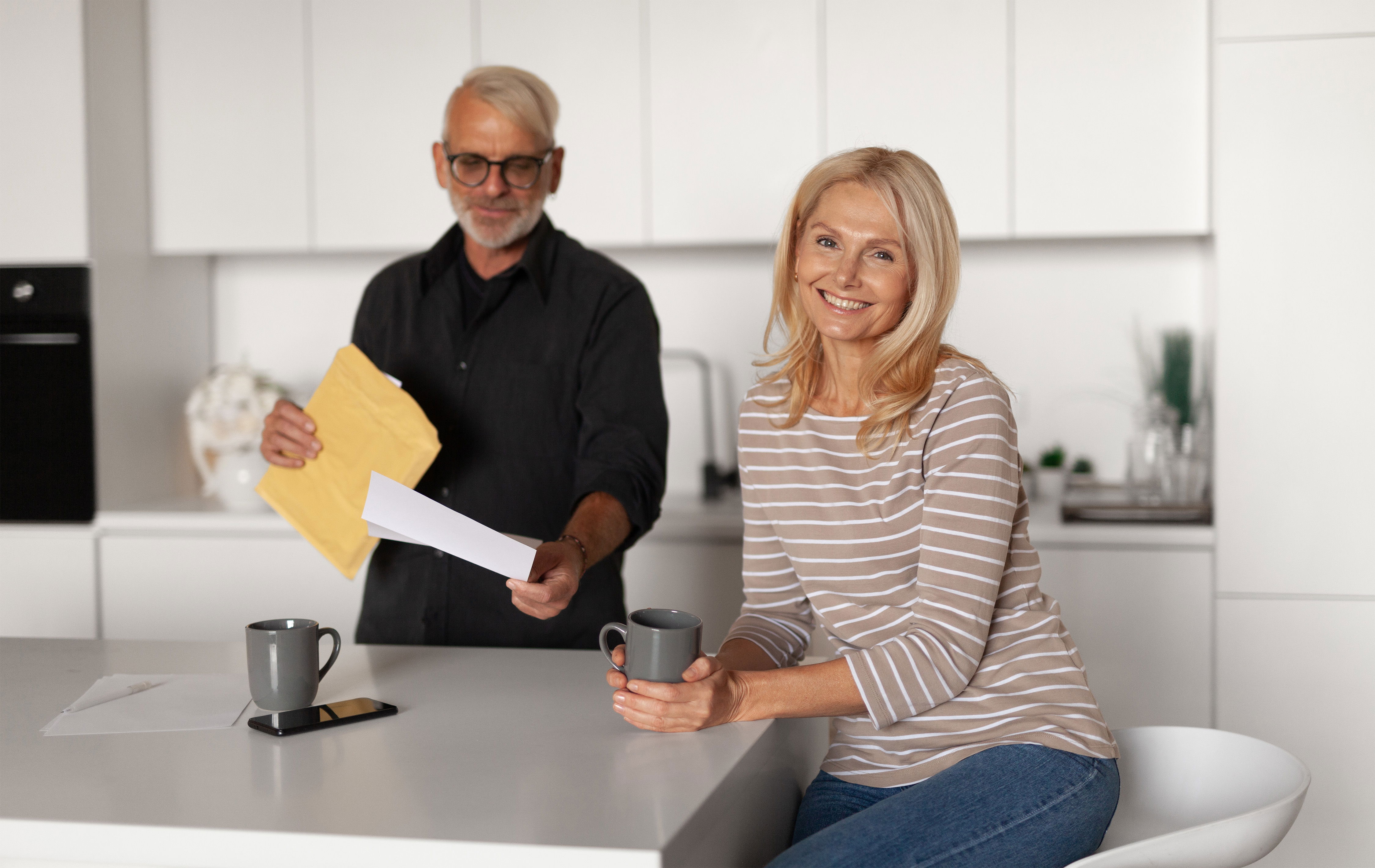 couple at a kitchen table with paperwork / tea mugs] (Warm, real-life feel)